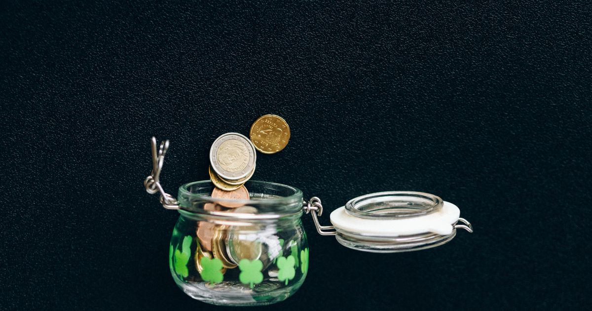 Monedas cayendo en un tarro de ahorro
